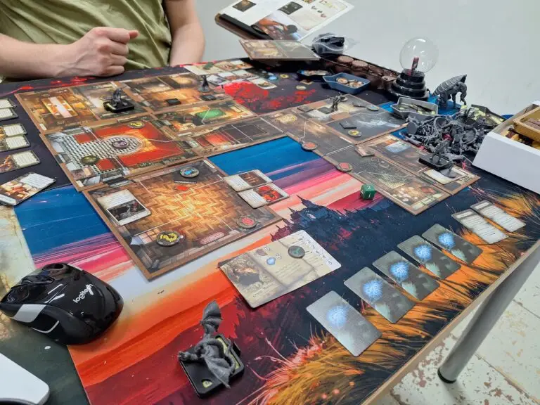 Club members playing Mansions of Madness at Warsaw Board Game Club — modular room tiles, monster miniatures, and exploration cards